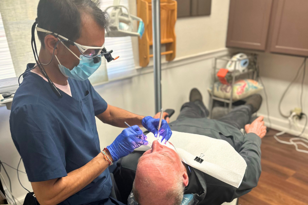 Dental hygienist at Dr. Haselhort's Naperville dental office cleaning a patient's teeth.